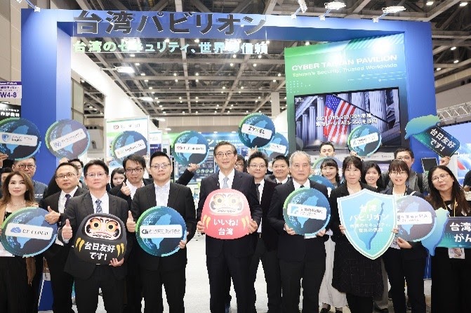 Exhibitors holding shield-shaped signs at the Taiwan Pavilion